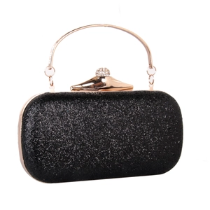 Detail of black sequin evening clutch with rhinestone lock and gold metal handle