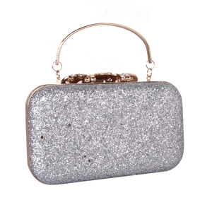 Silver sequin evening clutch bag with gold handle and sparkling rhinestone bow clasp
