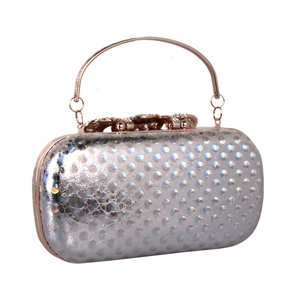 Detail of silver holographic evening clutch with dot texture and rose gold diamond bow clasp