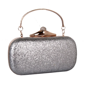 Detail of glitter evening clutch featuring rose gold ring handle and diamond clasp lock