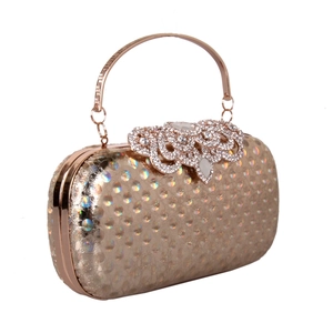 Detail of rose gold clutch with holographic polka dots and rhinestone floral clasp
