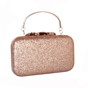 Detail of rose gold sequin evening clutch with crystal flower clasp and metal handle