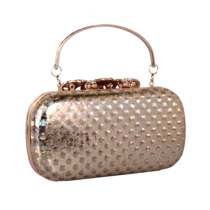 Macro detail of champagne gold evening clutch featuring 3D dot texture and floral diamond clasp