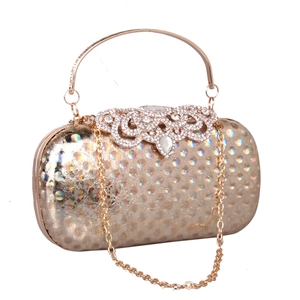 Macro detail of holographic polka dots and rhinestone buckle on luxury evening clutch bag