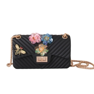 Detail of black jelly crossbody bag with floral accents and bee embroidery