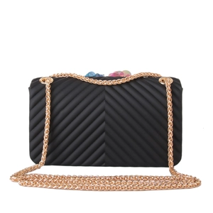Detail of black silicone crossbody bag with wave texture and colorful floral accents