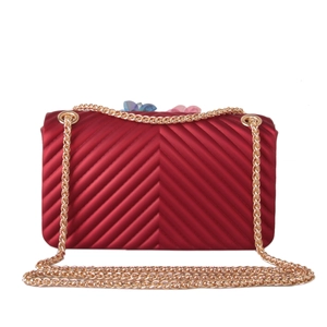 Close-up of deep red matte silicone crossbody bag with V-shaped texture and gold chain