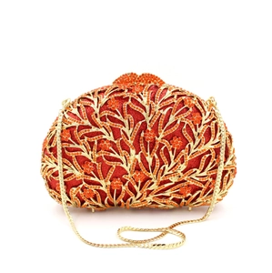 Detailed view of red rhinestones and gold floral hollow pattern on the clutch