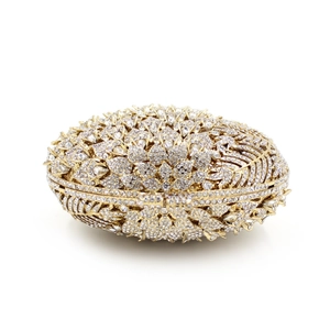 Close-up of gold metal evening bag featuring intricate floral crystal and rhinestone patterns