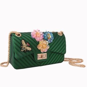 Green jelly crossbody bag with V-quilt texture, floral accents, and gold chain strap