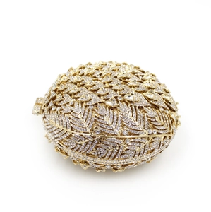 Detailed view of luxury gold oval evening clutch with crystal leaf carvings and rhinestones