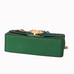 Detail view of emerald green silicone bag with 3D floral accents and gold chain strap