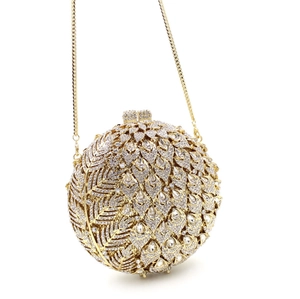 Detailed close-up of golden round evening clutch with shimmering crystals and metal chain