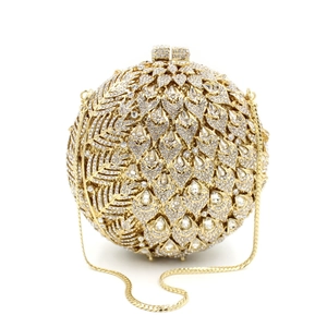 Macro shot of champagne gold spherical evening bag with sparkling crystal leaf pattern
