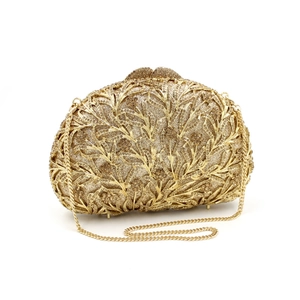 Close-up of golden hollow evening clutch with crystals and detachable chain strap