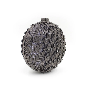 Macro view of crystal encrusted evening clutch bag with leaf and scale pattern details