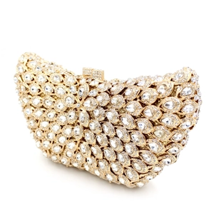 Close-up of sparkling floral crystal rhinestones on a gold hollow evening clutch bag