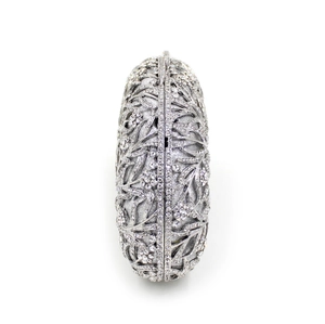 Detail of silver evening clutch featuring hollow flower patterns and sparkling rhinestones