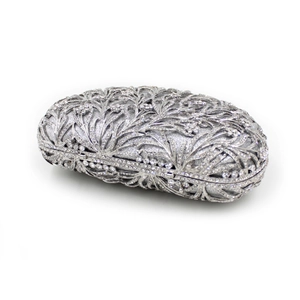 Macro detail of silver floral hollow metal frame and sparkling rhinestones on evening bag