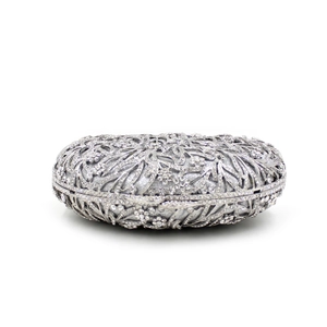 Macro view of silver floral hollow frame and sparkling crystals on evening clutch bag