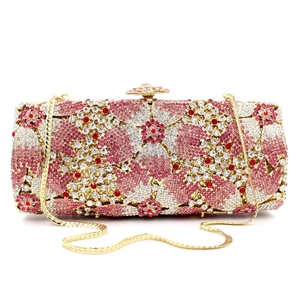 Macro shot of rhinestone evening bag with pink floral patterns and gold flower clasp