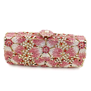 Macro detail of evening clutch with floral rhinestone patterns and golden metal frame