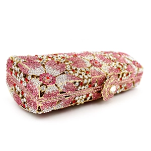 Detail of floral rhinestone patterns and decorative metal flower clasp on luxury clutch