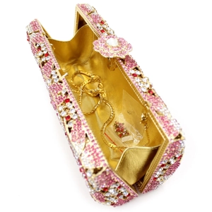Internal view of pink rhinestone evening clutch featuring gold chain and spare crystals