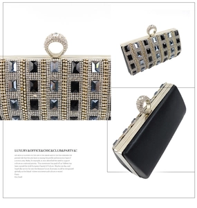 Close-up of luxury evening clutch featuring crystal ring clasp and navy blue rhinestones