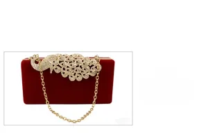 Detail der burgunderroten Samt-Clutch mit Pfauen-Strass-Verschluss und Goldkette