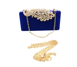Detail der königsblauen Samt-Clutch mit Strass-Pfau und goldener Kettenriemen
