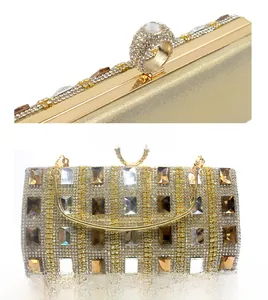 Detail of gold evening clutch featuring rhinestone ring clasp and crystal-embellished body