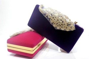 Makroaufnahme von Pfauen-Samt-Abendtaschen mit glitzernden Strasssteinen und Goldrahmen