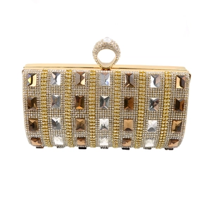 Detail of luxury evening clutch featuring gold frame, white diamonds and amber crystals