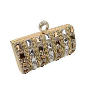 Detail of evening clutch with champagne crystals and ring handle on gold metal frame
