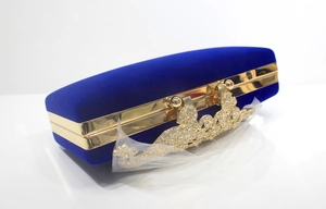 Detailansicht der königsblauen Samt-Clutch mit Pfauen-Strassverschluss und Goldrahmen