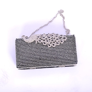 Detailed view of peacock rhinestone evening clutch bag with blue crystal accents and silver chain
