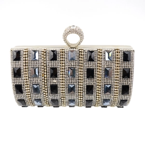 Close-up of evening clutch with striped rhinestones and sparkling ring-shaped clasp