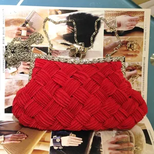 Detail of red woven evening clutch bag featuring a silver metal frame and ball clasp