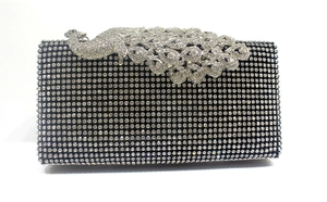 Detail shot of sparkling black crystal evening clutch with ornate silver peacock clasp