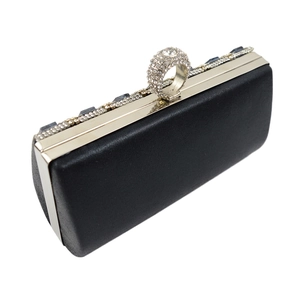 Detail of black satin clutch with silver metal frame and crystal ring clasp closure