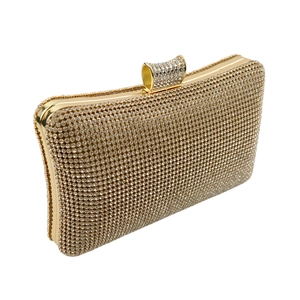 Détail de pochette de soirée luxueuse avec fermoir nœud en strass et cadre en métal doré