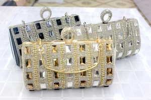 Detail of evening clutch with crystal rhinestones and knuckle ring closure in three colors