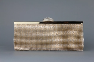 Detailed macro view of champagne gold rhinestones and metallic frame of the evening clutch