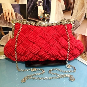 Detail of red woven evening clutch with rhinestone trim and silver chain strap