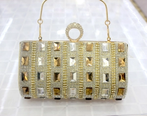 Detailed view of luxury gold evening clutch with amber crystals and diamond ring handle