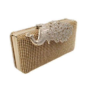 Macro shot of gold peacock evening clutch featuring luxury rhinestones and crystal metal clasp