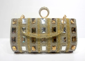 Close-up of evening clutch with rhinestones, colorful gems, and gold ring handle