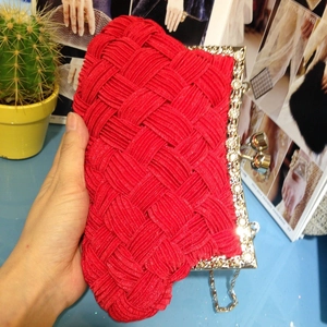 Close-up of red woven satin bridal clutch featuring diamond-encrusted silver frame and chain