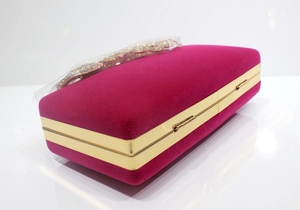 Seitenansicht der luxuriösen magentafarbenen Samt-Clutch mit Goldrahmen und Strass